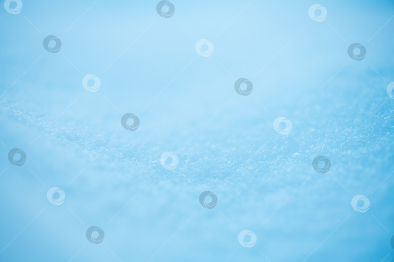 Скачать Слой голубого снега, покрывающий землю, создает холодную, мягкую текстуру и яркий абстрактный фон, идеально подходящий для зимних и сезонных дизайнерских проектов. фотосток Ozero