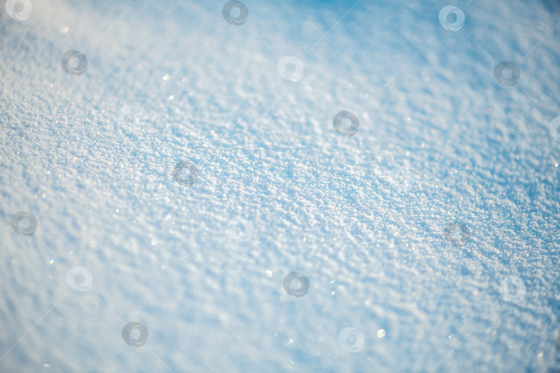Скачать Свежевыпавший снег создает нетронутое текстурированное покрывало, сверкающее крошечными кристаллами льда в холодном зимнем свете, абстрактная поверхность крупным планом демонстрирует иней, мерцание и чистый белый покой фотосток Ozero