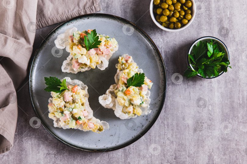 Скачать Порционный салат Оливье оригинально подается на тарелке на столе вид сверху фотосток Ozero