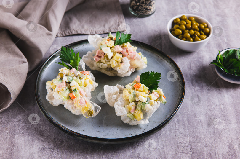 Скачать Салат Оливье в мисочках из рисовой бумаги на тарелке на столе фотосток Ozero