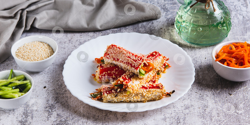 Скачать Огурцы и корейская морковь, завернутые в крабовое мясо и обжаренные с кунжутом на тарелке web banner фотосток Ozero