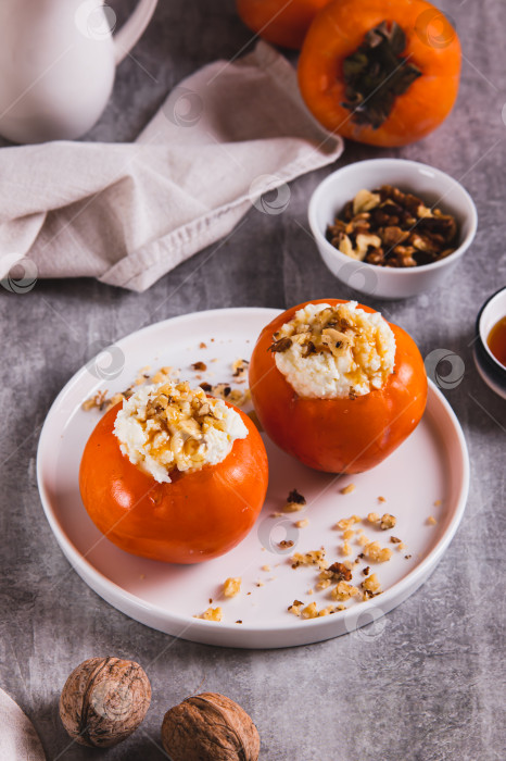 Скачать Сладкая хурма, фаршированная творогом и грецкими орехами, на тарелке, вид сверху фотосток Ozero