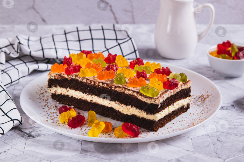 Скачать Шоколадный торт, украшенный мармеладными мишками, на тарелке на столе фотосток Ozero
