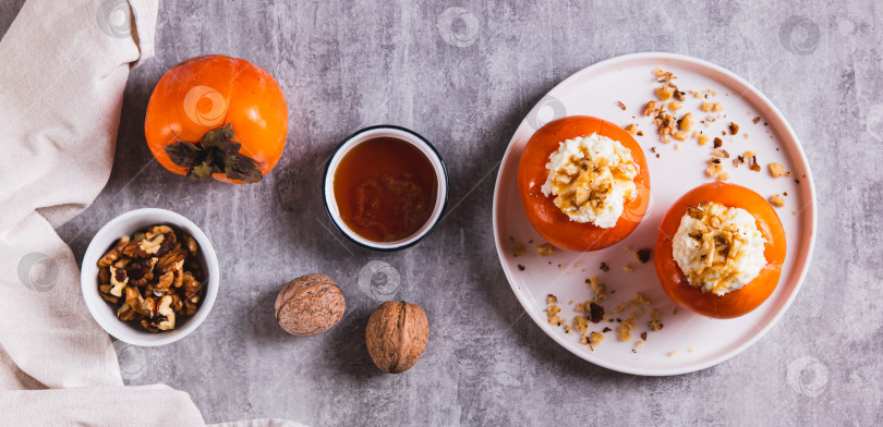 Скачать Сладкая хурма, фаршированная творогом и грецкими орехами на тарелке вид сверху веб-баннер фотосток Ozero