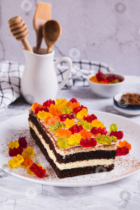 Скачать Шоколадный торт, украшенный мармеладными мишками, на тарелке на столе, вид сверху фотосток Ozero