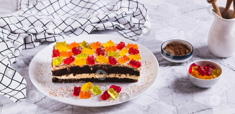 Скачать Шоколадный торт, украшенный мармеладными мишками, на тарелке на веб-баннере стола фотосток Ozero