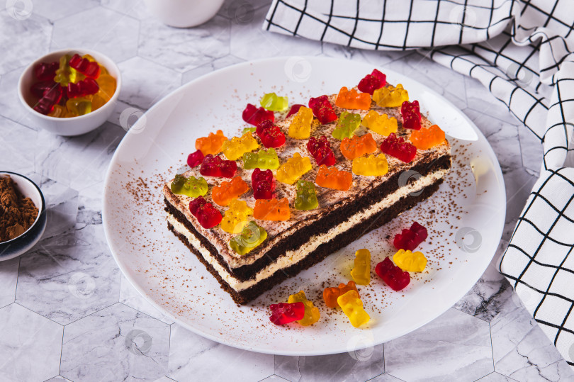 Скачать Сладкий тирамису с мармеладными мишками на тарелке на столе фотосток Ozero