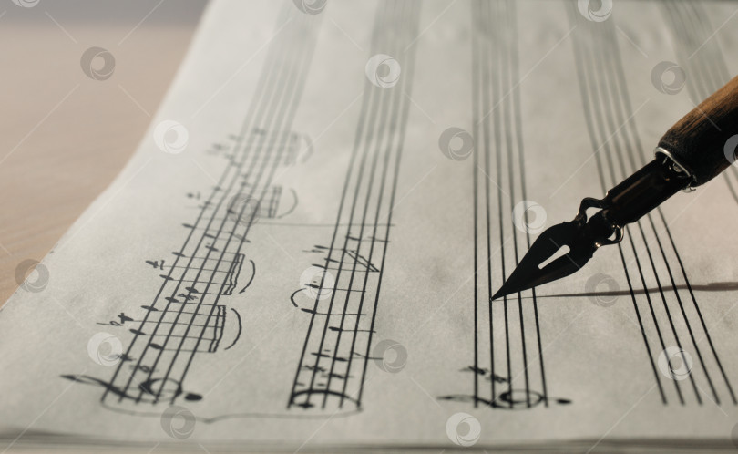 Скачать Лист с рукописными заметками и чернильной ручкой крупным планом, вид сбоку, написание музыкальных символов фотосток Ozero