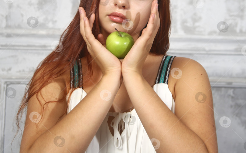 Скачать Молодая женщина держит в руках яблоко фотосток Ozero