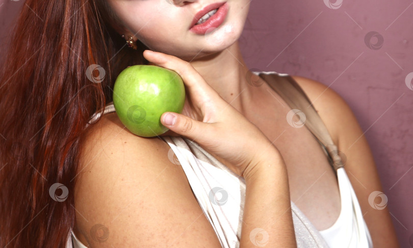 Скачать Молодая женщина держит в руках яблоко фотосток Ozero