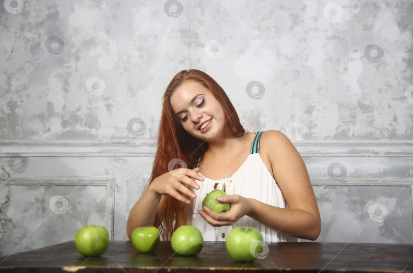 Скачать Молодая женщина держит в руках яблоки фотосток Ozero