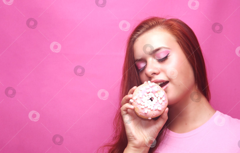 Скачать Красивая девушка в розовой кофте с пончиком фотосток Ozero