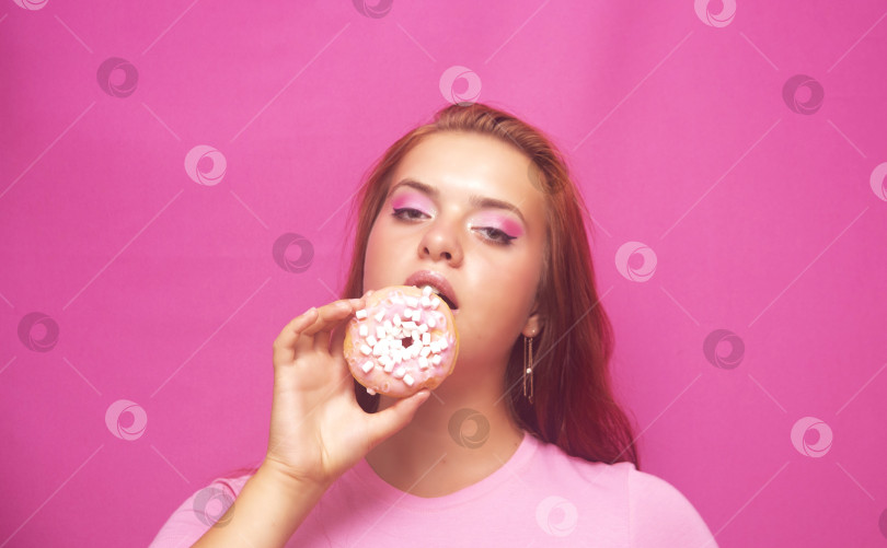 Скачать Красивая девушка в розовой кофте с пончиком фотосток Ozero