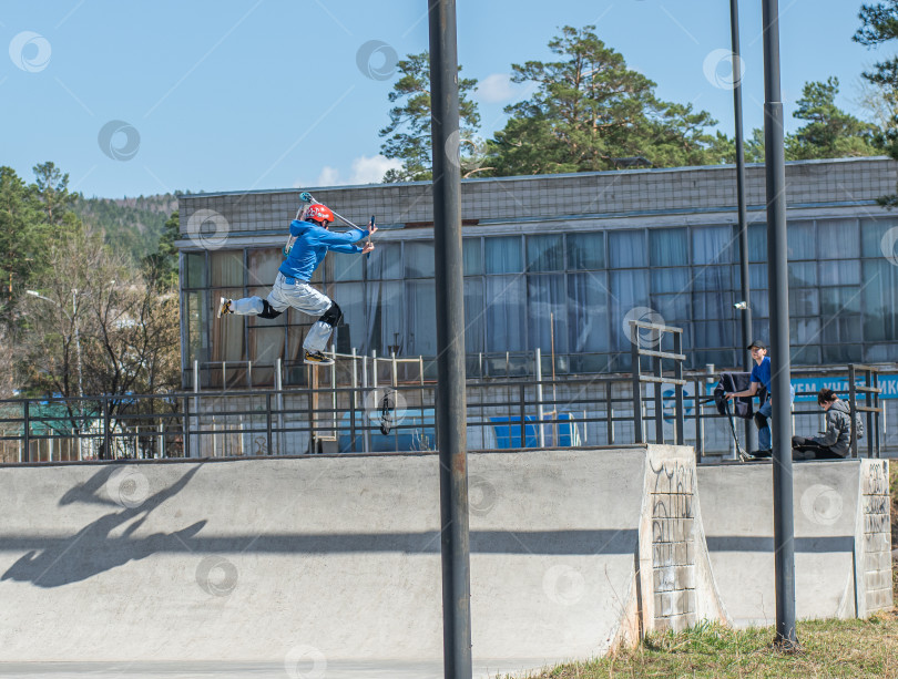 Скачать Россия, Красноярск 02 мая 2025г. Подросток на трюковом самокате в скейт-парке выполняет трюк во время прыжка. фотосток Ozero