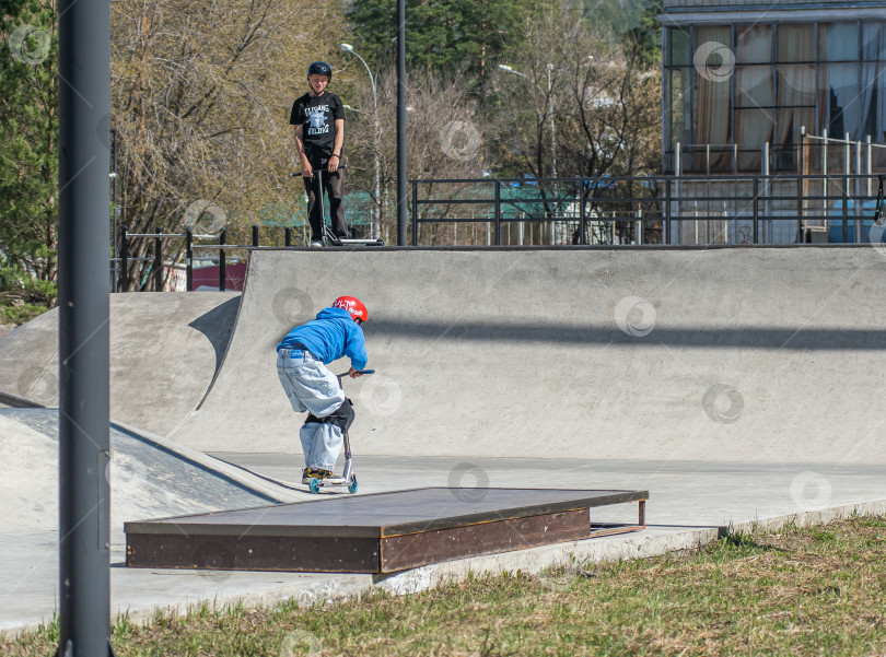 Скачать Россия, Красноярск 02 мая 2025г. Подросток на трюковом самокате в скейт-парке выполняет трюк во время прыжка. фотосток Ozero