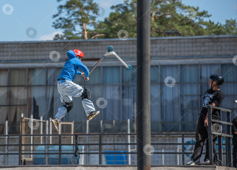 Скачать Россия, Красноярск 02 мая 2025г. Подросток на трюковом самокате в скейт-парке выполняет трюк во время прыжка. фотосток Ozero