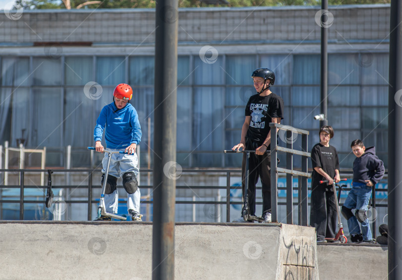 Скачать Россия, Красноярск 02 мая 2025г. Подросток на трюковом самокате в скейт-парке выполняет трюк во время прыжка. фотосток Ozero