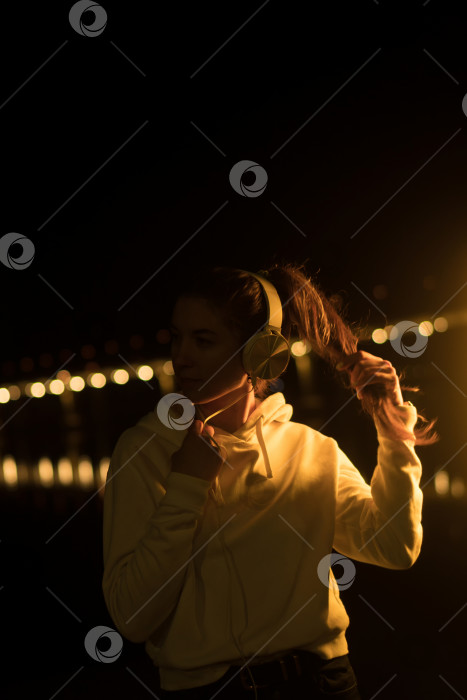 Скачать Тысячелетняя Девушка Слушает музыку Неоновый свет на открытом воздухе фотосток Ozero