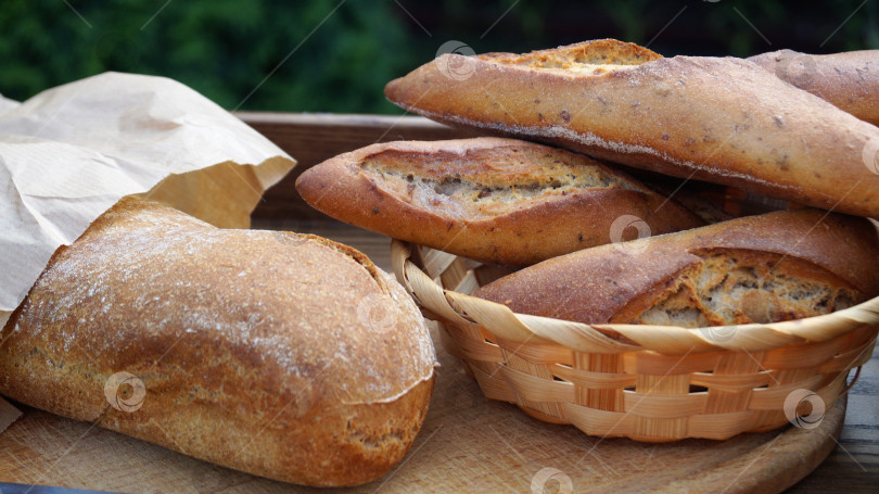 Скачать свежий хлеб в плетеной корзине на деревянном столе фотосток Ozero