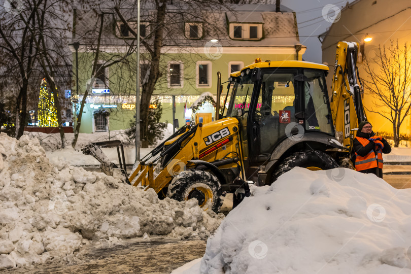 Скачать Москва, Россия - 11.01.2026: [Уборка снега трактором и дворником в центре Москвы] фотосток Ozero