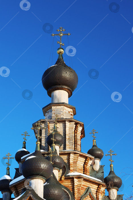 Скачать Санарка, Россия - 11 февраля 2024 года: купола и кресты деревянной церкви иконы Божией Матери “Скоропослушница” зимой на фоне ярко-голубого неба. фотосток Ozero