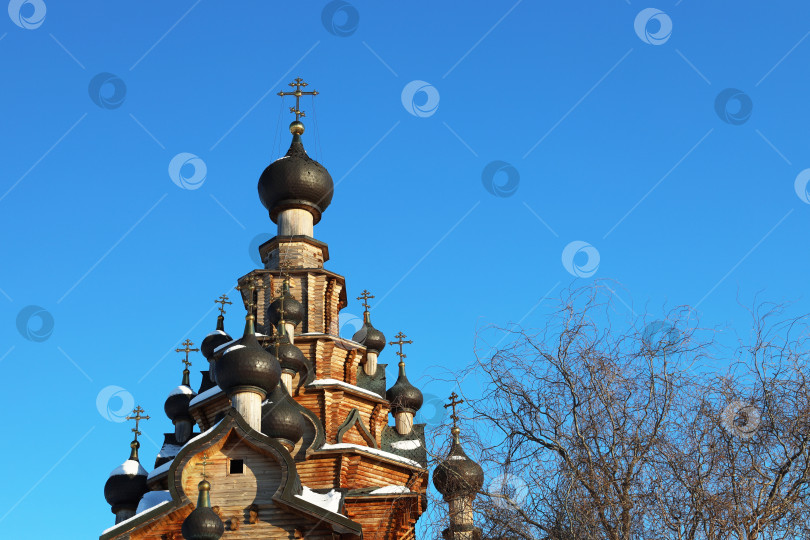 Скачать Санарка, Россия - 11 февраля 2024 года: Деревянная церковь иконы Божией Матери “Скоропослушница” освещена лучами заходящего зимнего солнца фотосток Ozero