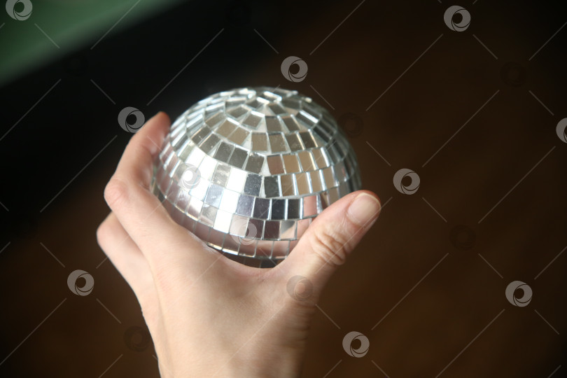 Скачать Женская рука держит блестящий шар фотосток Ozero
