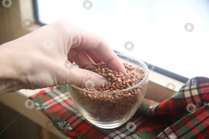 Скачать Женская рука держит миску с гречкой фотосток Ozero