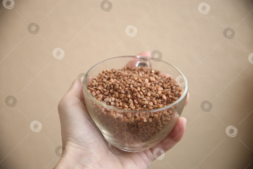 Скачать Женская рука держит миску с гречкой фотосток Ozero