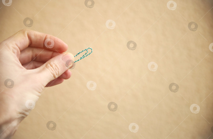 Скачать Рука держащая канцелярскую скрепку фотосток Ozero