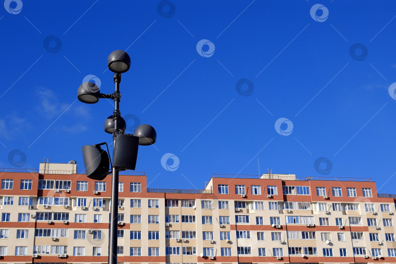 Скачать Осветительный фонарь на фоне неба и многоэтажного дома. фотосток Ozero