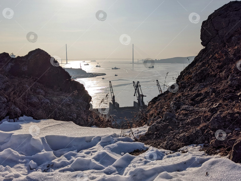 Скачать Владивосток в январе 2026: Зимний пейзаж со скалами и сверкающим морем фотосток Ozero