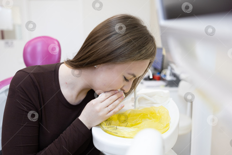 Скачать Пациент вытирает рот салфеткой после посещения стоматолога фотосток Ozero