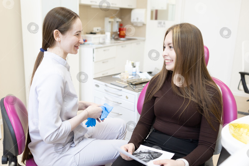 Скачать Стоматолог консультирует пациента, делая рентгеновский снимок зубов. Стоматолог показывает пациенту рентгеновский снимок фотосток Ozero