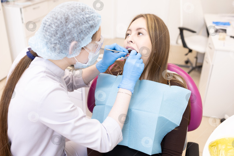 Скачать стоматолог лечит зубы пациента.Стоматолог и пациент в современном медицинском центре. фотосток Ozero