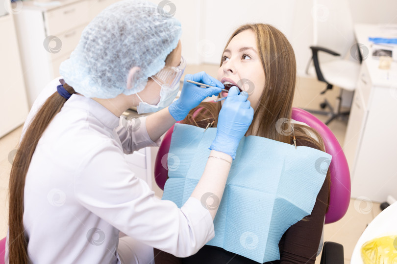 Скачать стоматолог лечит зубы пациента.Стоматолог и пациент в современном медицинском центре. фотосток Ozero