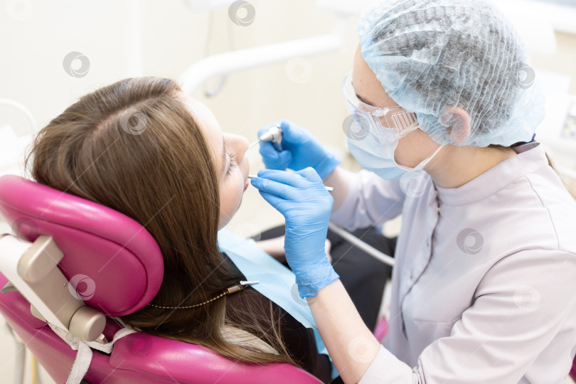 Скачать стоматолог лечит зубы пациента.Стоматолог и пациент в современном медицинском центре. фотосток Ozero