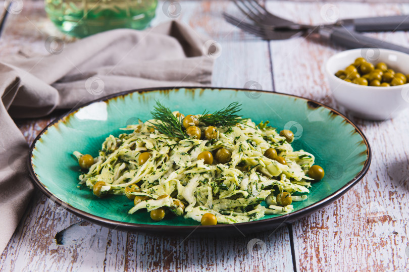 Скачать Зеленый салат с капустой, горошком и укропом на тарелке на стол фотосток Ozero