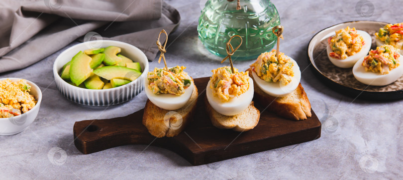 Скачать Жареные яйца с помидорами и авокадо на тосте на доске объявлений фотосток Ozero