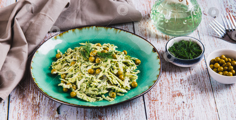 Скачать Зеленый салат с капустой, горошком и укропом на тарелке на столе - веб-баннер фотосток Ozero