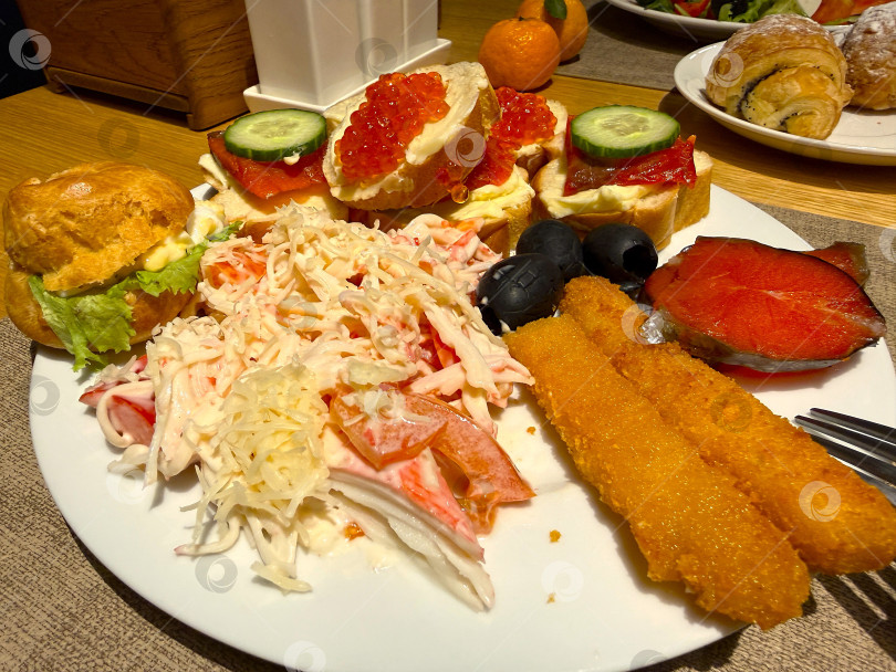 Скачать Традиционный камчатский завтрак со свежим крабовым салатом, кальмарами в хрустящей панировке, красной икрой и ломтиками лосося. Элегантная ресторанная презентация местных деликатесов из морепродуктов. Идеально подходит для фуд-фотосъемки, создания меню, кафе, блюд туристической кухни и концепций завтраков премиум-класса. фотосток Ozero