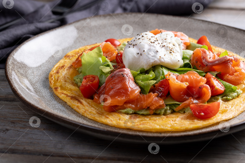 Скачать Лепешка роти с авокадо, помидорами, лососем и яйцом-пашот фотосток Ozero