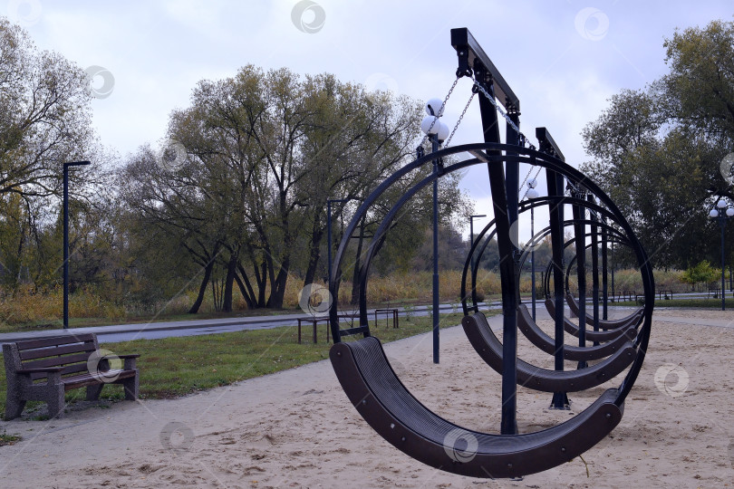 Скачать Качели для отдыха в парке Осенний дождливый день. Пасмурное небо. фотосток Ozero