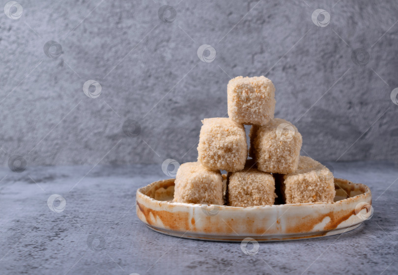 Скачать Замороженные рыбные палочки в панировке на керамической тарелке на сером фоне фотосток Ozero