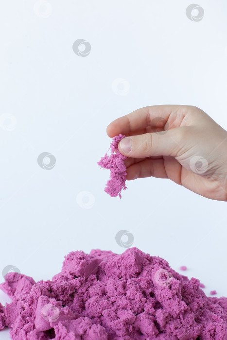 Скачать Фиолетовый кинетический песок в руке, выделенный на белом фоне. фотосток Ozero