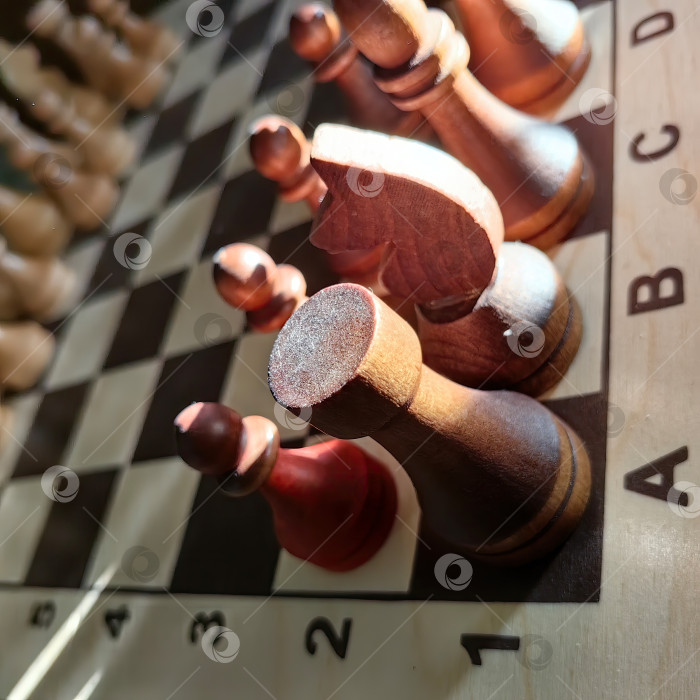 Скачать Крупный план деревянных шахматных фигур на доске с эффектным освещением фотосток Ozero