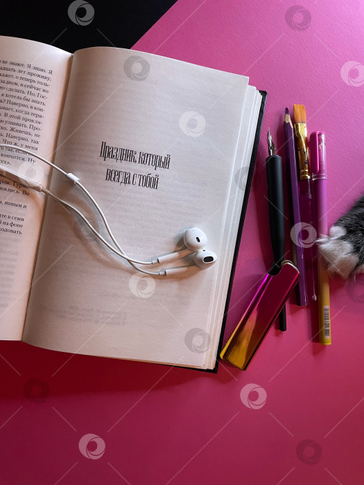Скачать Разворот книги, проводные наушники, письменные принадлежности и лапка кота фотосток Ozero