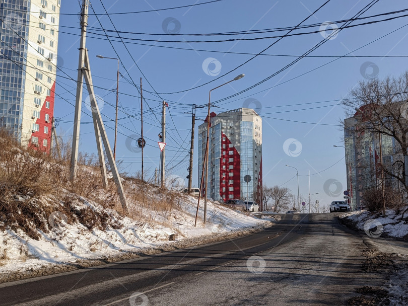 Скачать Дорога к высоким домам на фоне голубого неба в зимнем Владивостоке фотосток Ozero