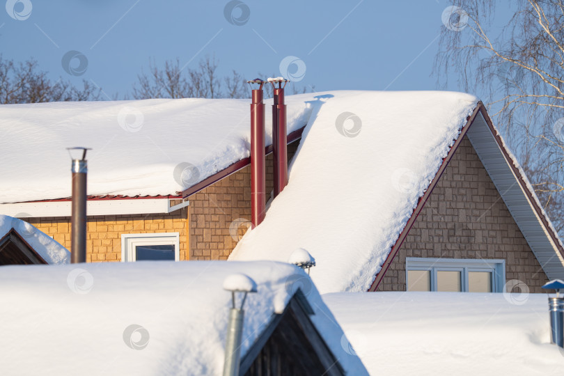 Скачать заснеженные крыши домов с дымоходами, солнечный зимний день фотосток Ozero