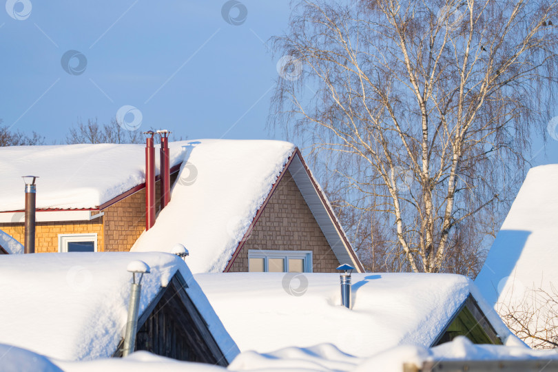 Скачать заснеженные крыши домов с дымоходами, солнечный зимний день фотосток Ozero